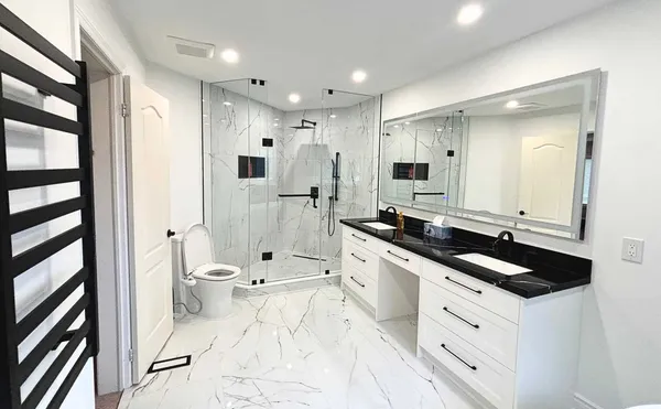 Modern condo bathroom renovation featuring walk-in frameless glass shower, floating vanity and contemporary fixtures