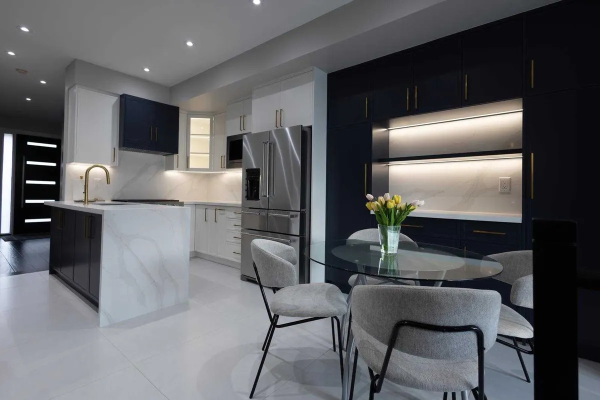Open concept kitchen renovation with custom island, quartz countertops, designer pendant lighting and modern cabinetry