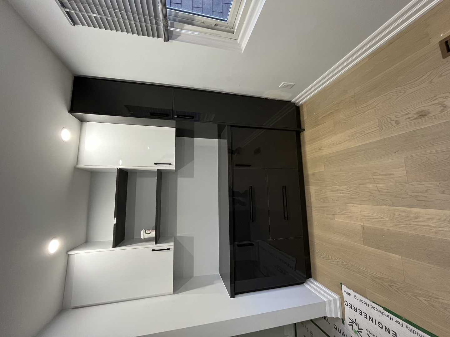 Black and white glossy finish walk-in pantry with black handles. - Image 2