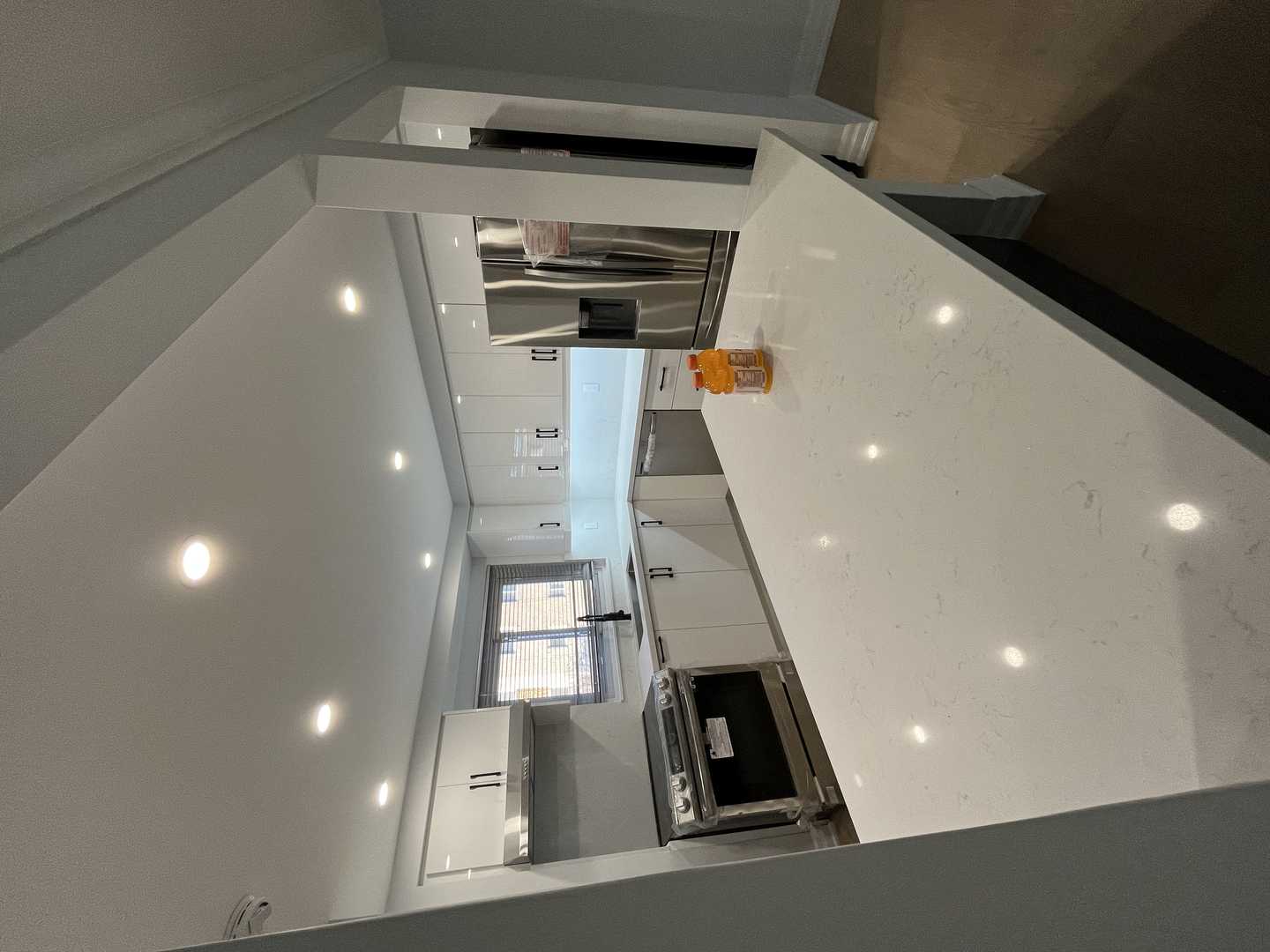 Black and white glossy finish walk-in pantry with black handles. - Image 3